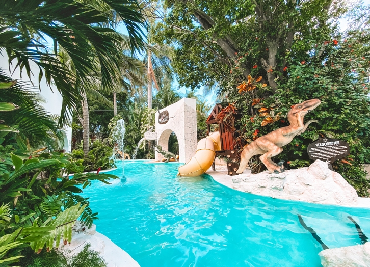Kids pool with dinosaurs, a water slide and fountains at Grand Oasis Palm